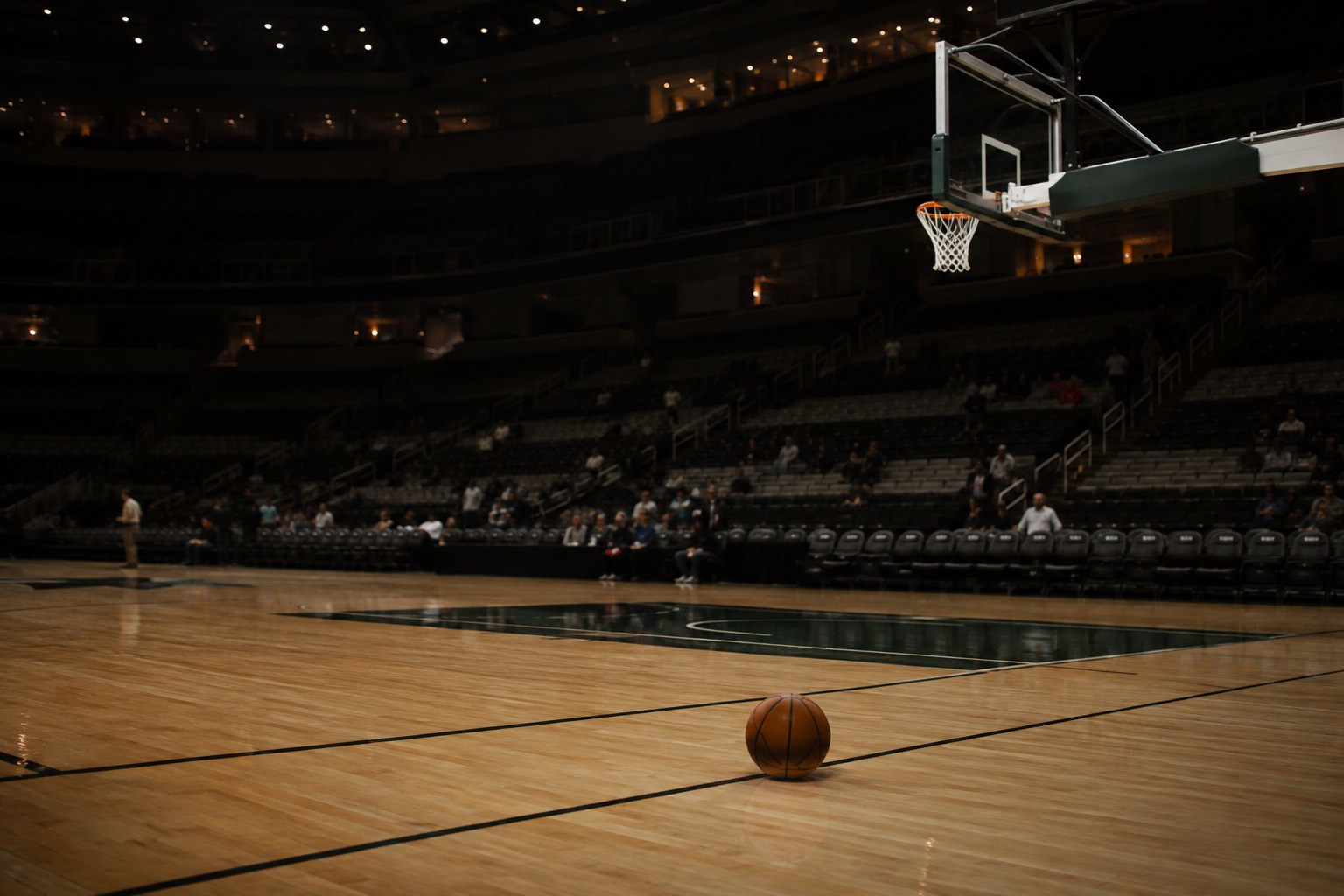 Illustrative photograph of a quiet basketball arena and hardwood court